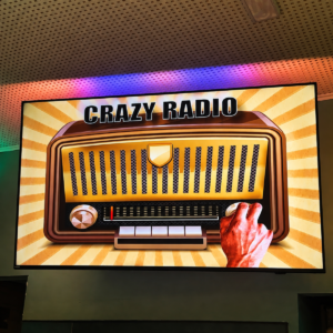 La grafica del round speciale Crazy Radio proiettata sul maxischermo durante il Kanta Game del martedì sera da 140 Grammi Sestu.